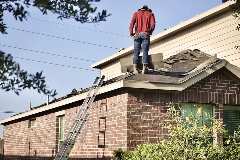 Professional roofer working on a residential roof in Palmer